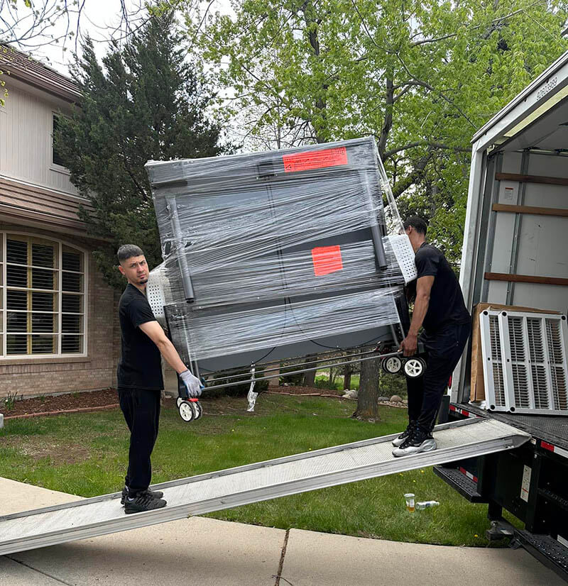 a moving crew loading an item in a truck